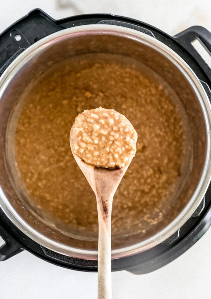 overhead view of a spoon lifting pumpkin oatmeal from an instant pot.