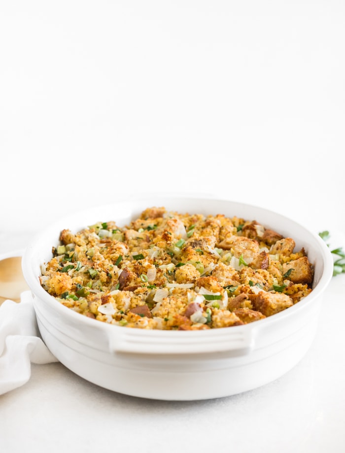 southern cornbread stuffing in a white oval baking dish.