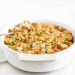 southern cornbread stuffing in a white oval baking dish.