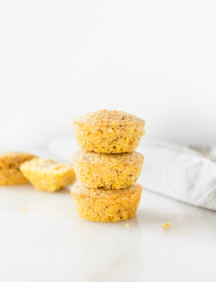 3 gluten-free polenta cornbread muffins stacked on top of each other.