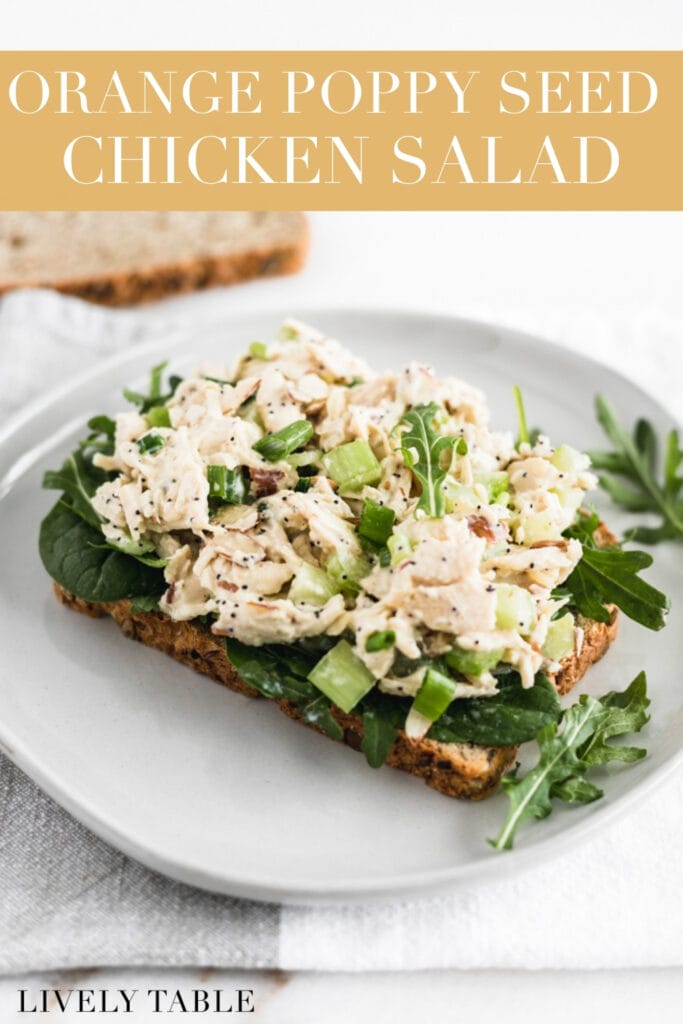 orange poppy seed chicken salad on top of a piece of bread on a white plate with text overlay.