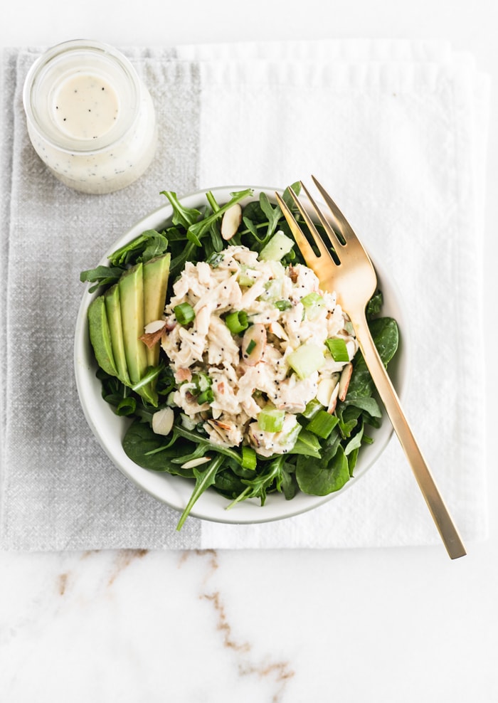 no mayo orange poppy seed chicken salad on greens in a bowl