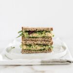 Close up of a smashed chickpea avocado salad sandwich cut in half stacked.