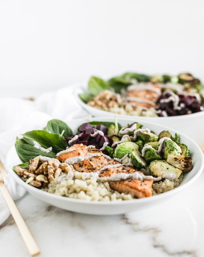 Salmon walnut quinoa bowls with walnut cream sauce in a white bowl.