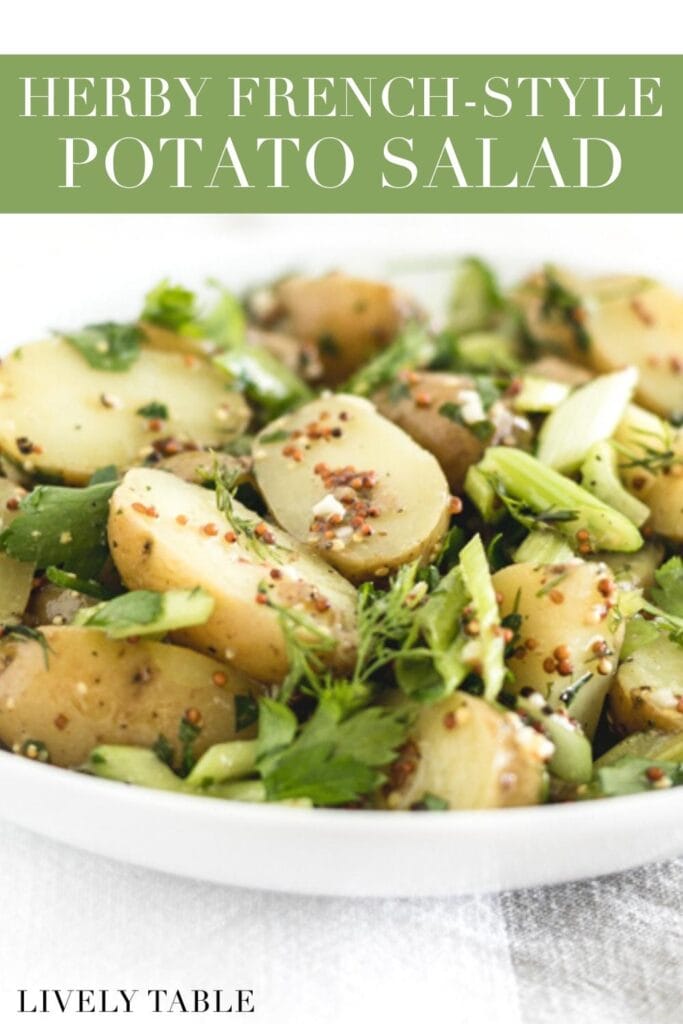 closeup of herby french style potato salad in a white bowl with text overlay.