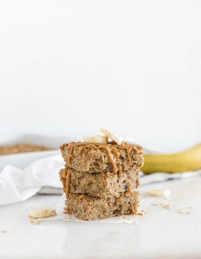 3 squares of peanut butter banana baked oatmeal stacked on top of each other.