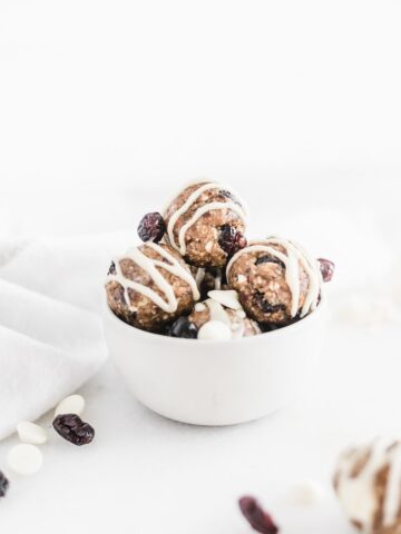 craberry bliss snack balls stacked in a white bowl.