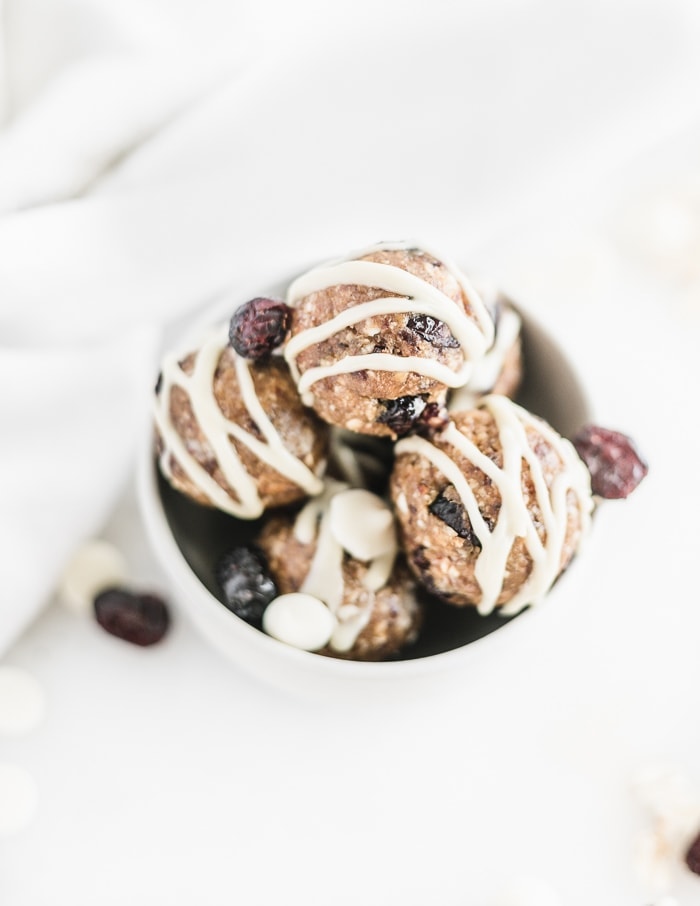 Overhead view of white chocolate cranberry bliss balls in a small white bowl.