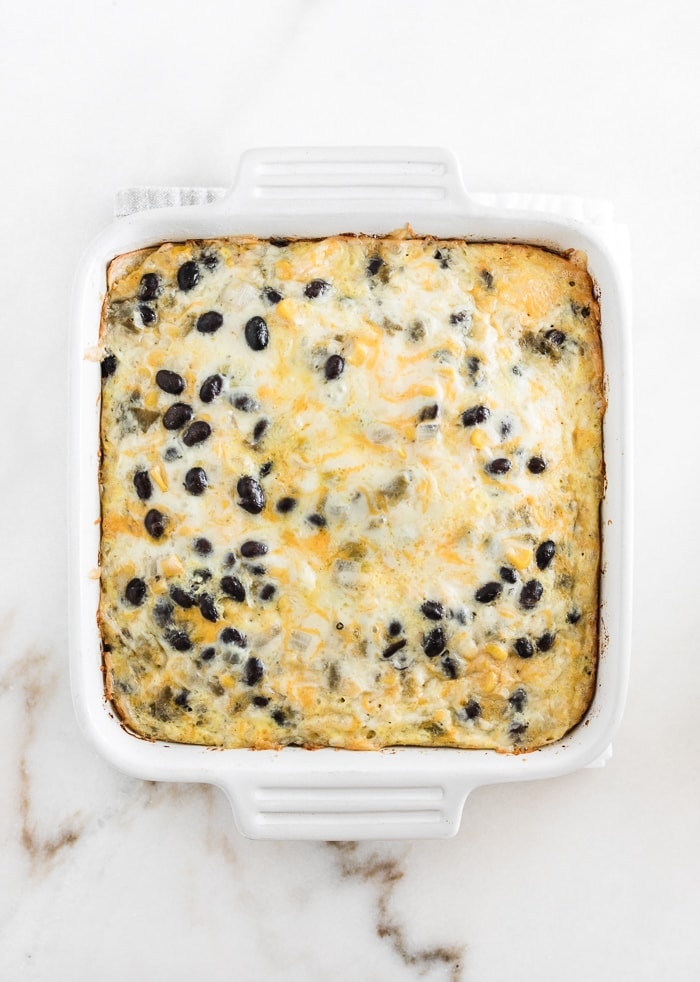 overhead view of baked cheesy mexican breakfast casserole in a white square baking dish.