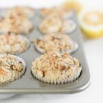 lemon poppyseed muffins with streusel topping in a muffin tin.