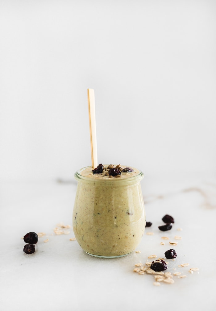 cranberry orange overnight oats in a jar with a gold spoon in it.