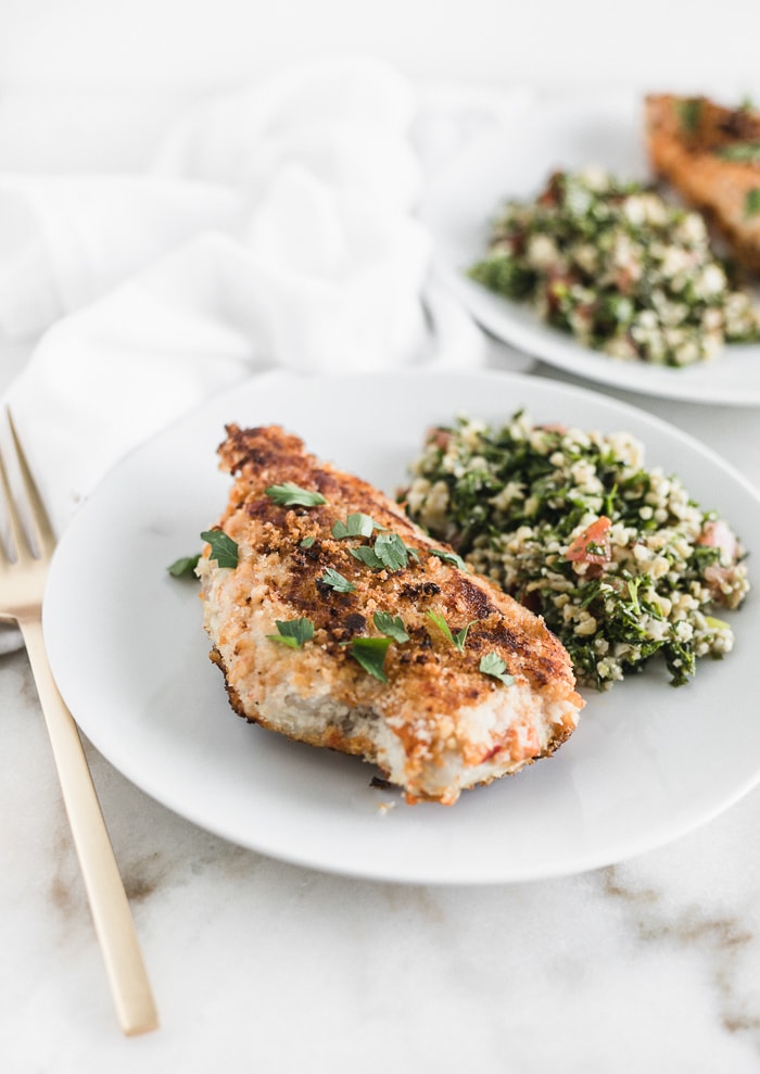 hummus chicken on a white plate with tabbouleh