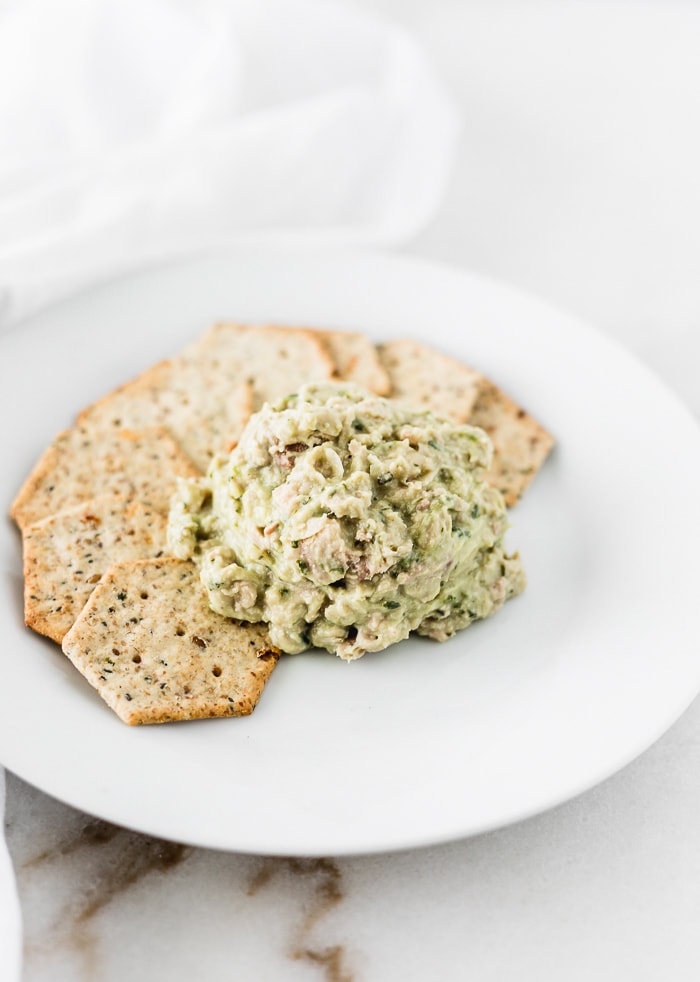 green goddess white bean tuna salad on a white plate with crackers.