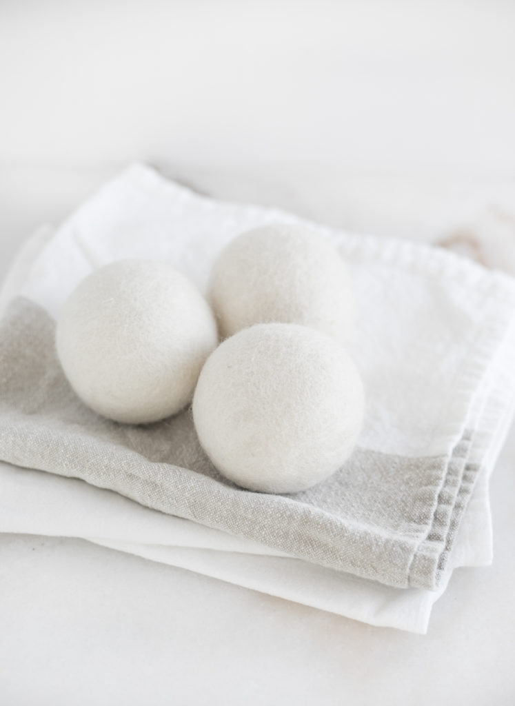 three wool dryer balls on top of folded towels