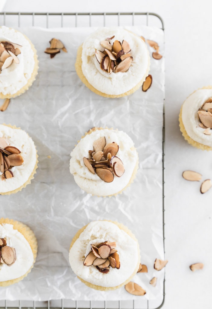 overhead view of burnt almond cupcakes on a cooling rackwith parchment paper underneath them.