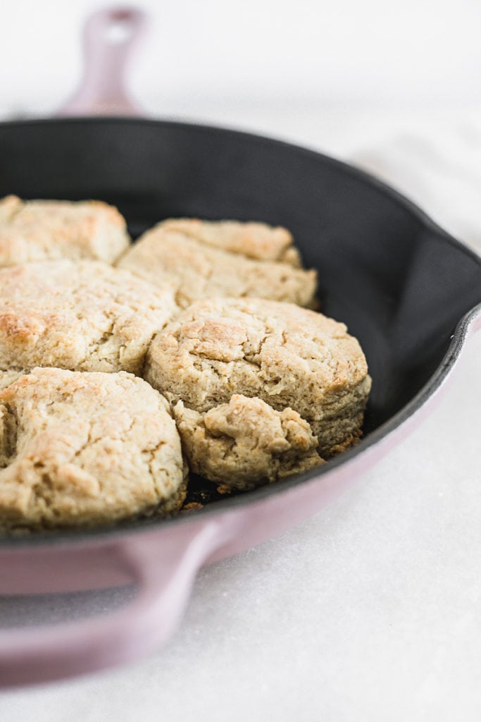 baked sourdough biscuits in a pink cast iron skillet.