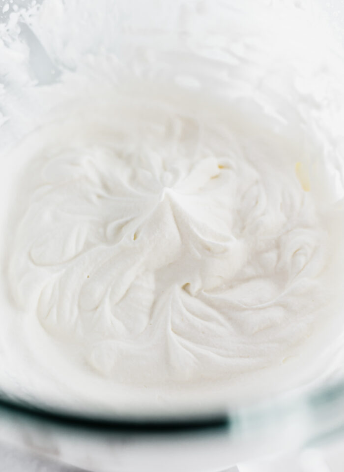 whipped cream in the soft peak stage in a glass bowl.