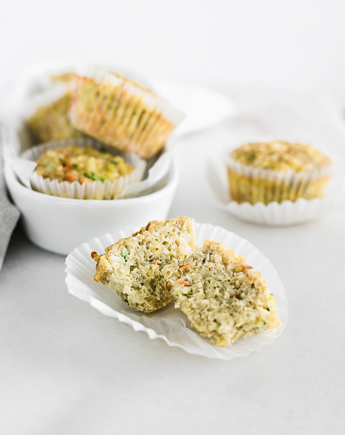 MUFFIN DE HUEVO DE QUINA Y VERDURAS EN UN LIBRO BLANCO CORTADO POR LA MITAD.