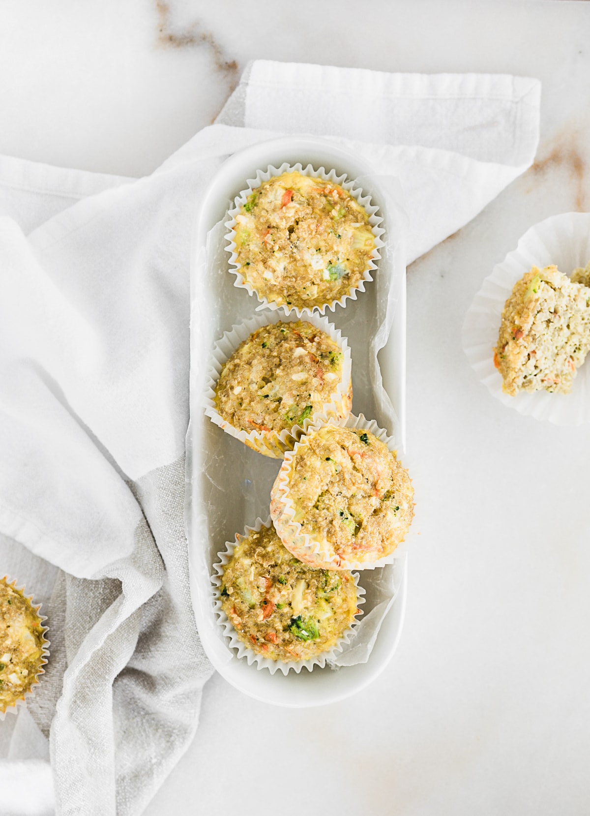 VISTA AÉREA DE MUFFINS DE QUINOA EN UNA PLACA OVAL BLANCA.
