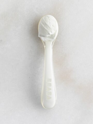 greek yogurt on a white baby spoon.
