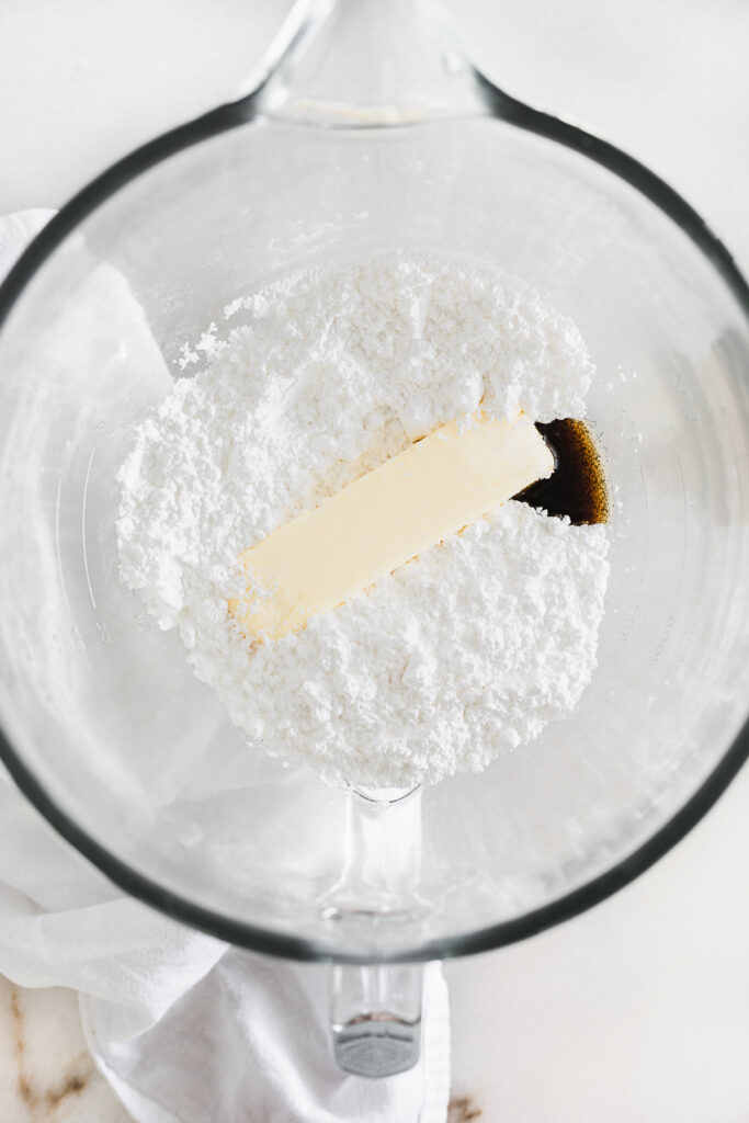 powdered sugar, butter, and vanilla in the bowl of a stand mixer.