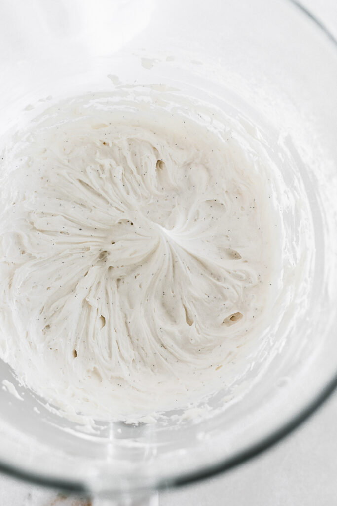 overhead view of vanilla frosting in the bowl of a stand mixer.
