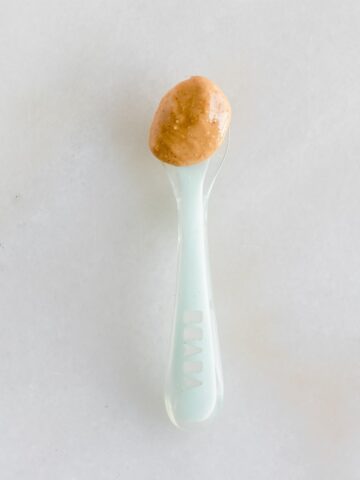 blue spoon with peanut butter in it.
