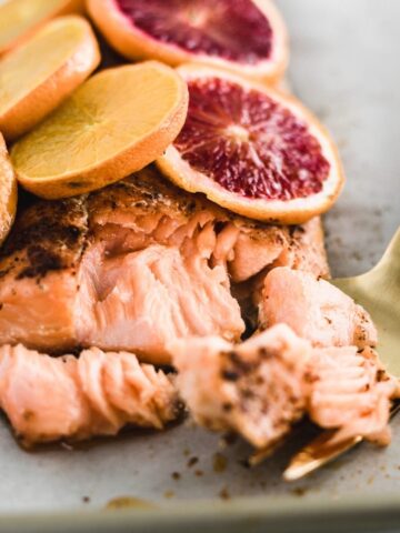 blood orange chili salmon with a gold fork flaking pieces off.
