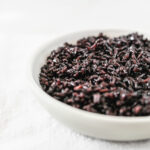 cooked black rice in a small grey bowl.