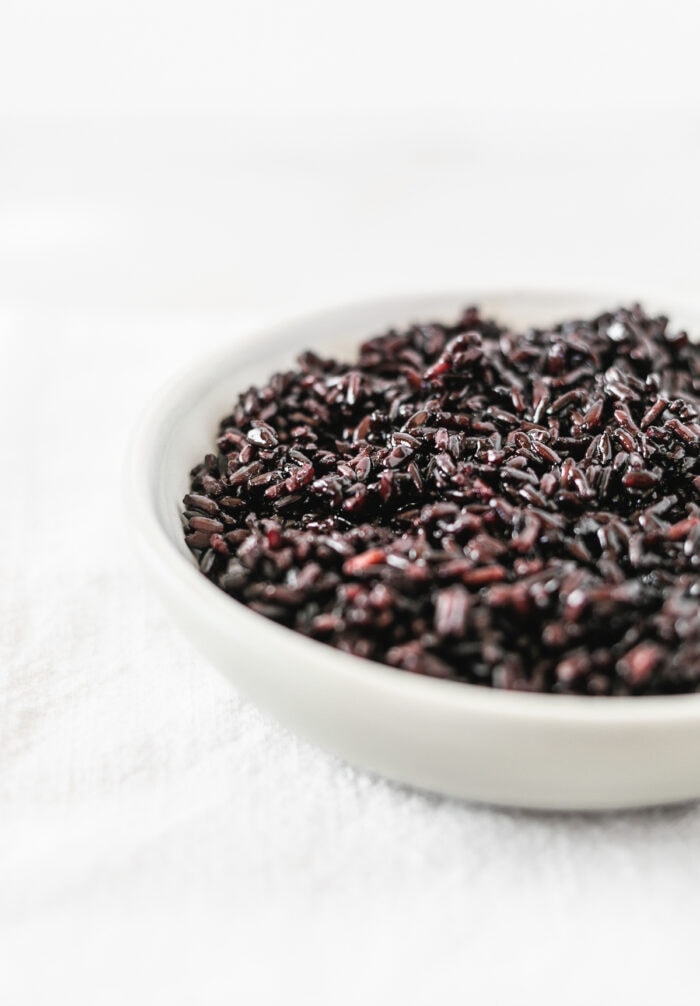 cooked black rice in a small grey bowl.