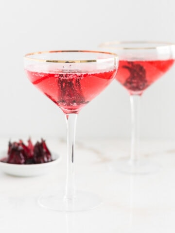 two hibiscus mimosas in champagne coupes.