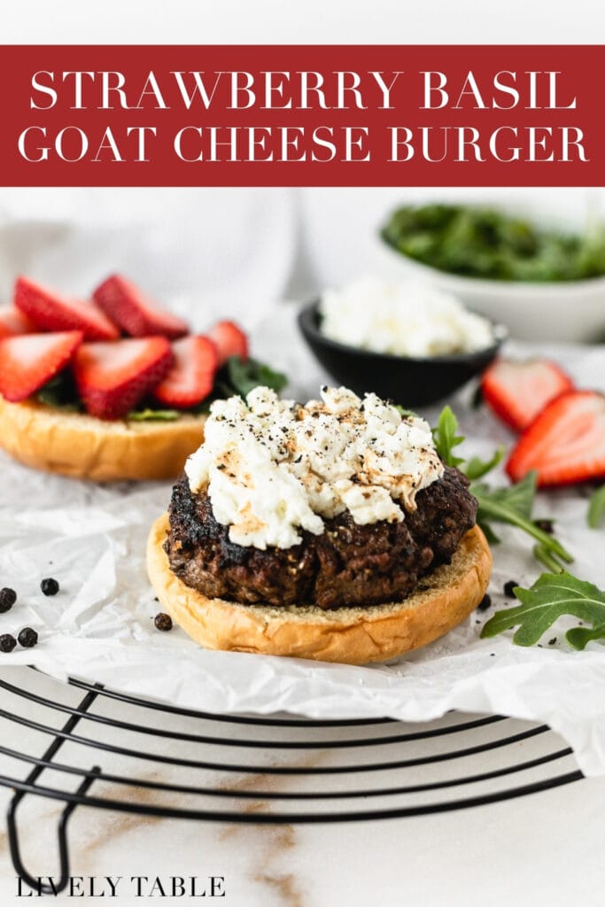 text overlay over a burger patty on a bottom bun topped with goat cheese with the top bun in the background topped with sliced strawberries.