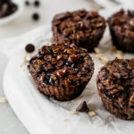 closeup of double chocolate zucchini baked oatmeal cups on a parchment lined plate.