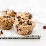 trail mix baked oatmeal muffins on a wire cooling rack lined with parchment.