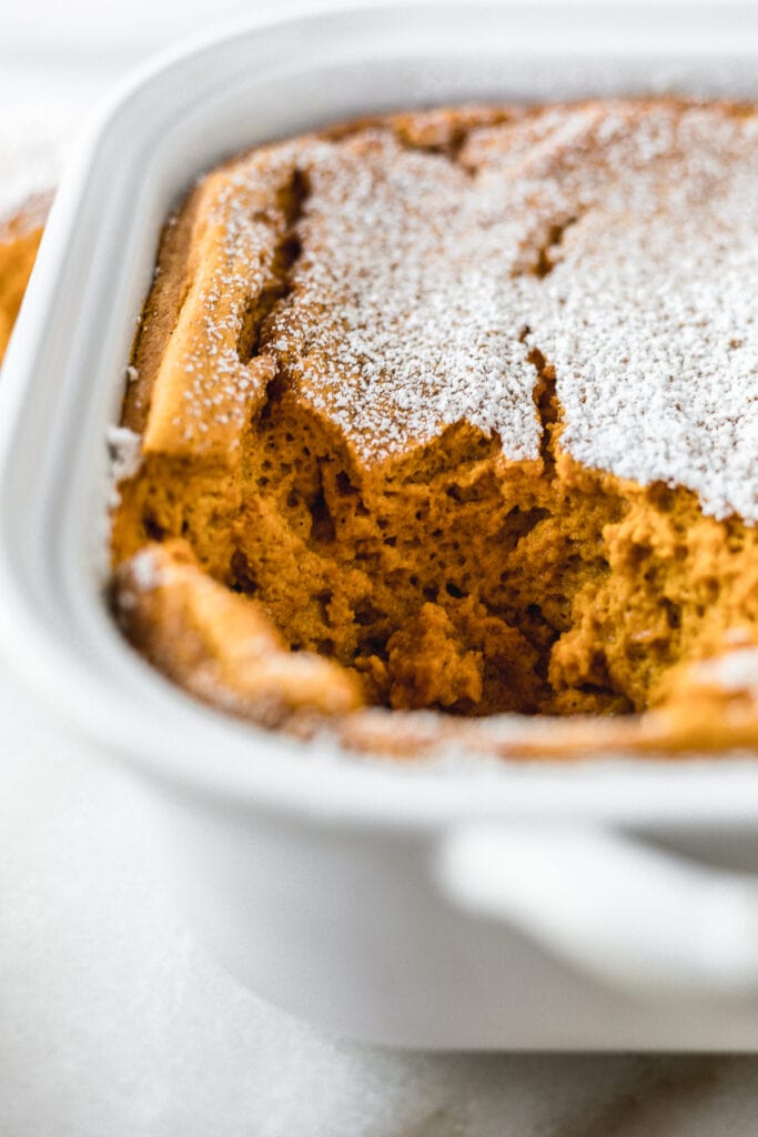 closeup of the inside of cinnamon ginger carrot souffle in a white baking dish.